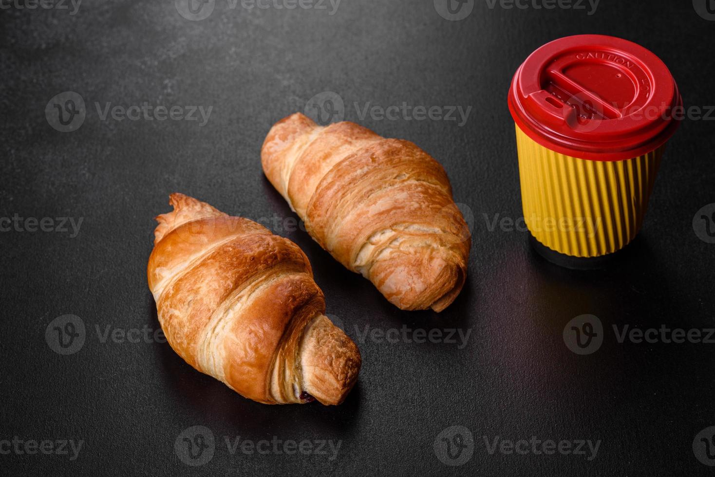 frisches knackiges leckeres französisches Croissant mit einer Tasse duftendem Kaffee foto