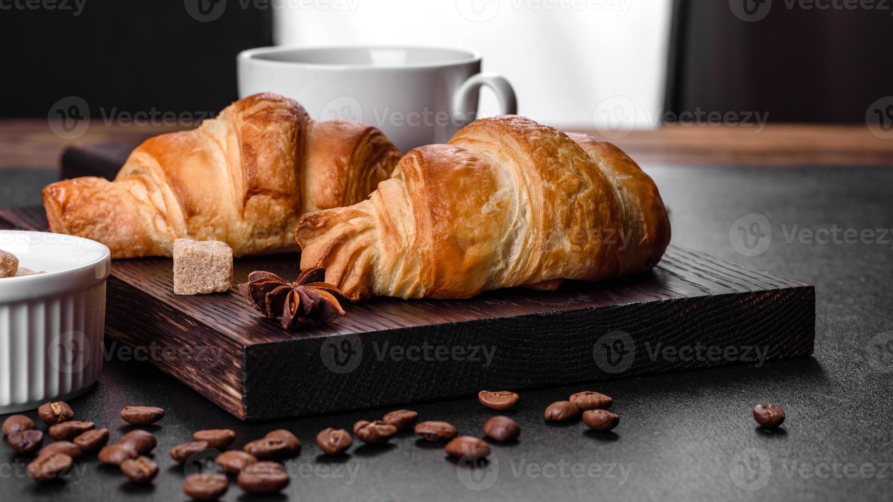 frisches knackiges leckeres französisches Croissant mit einer Tasse duftendem Kaffee foto