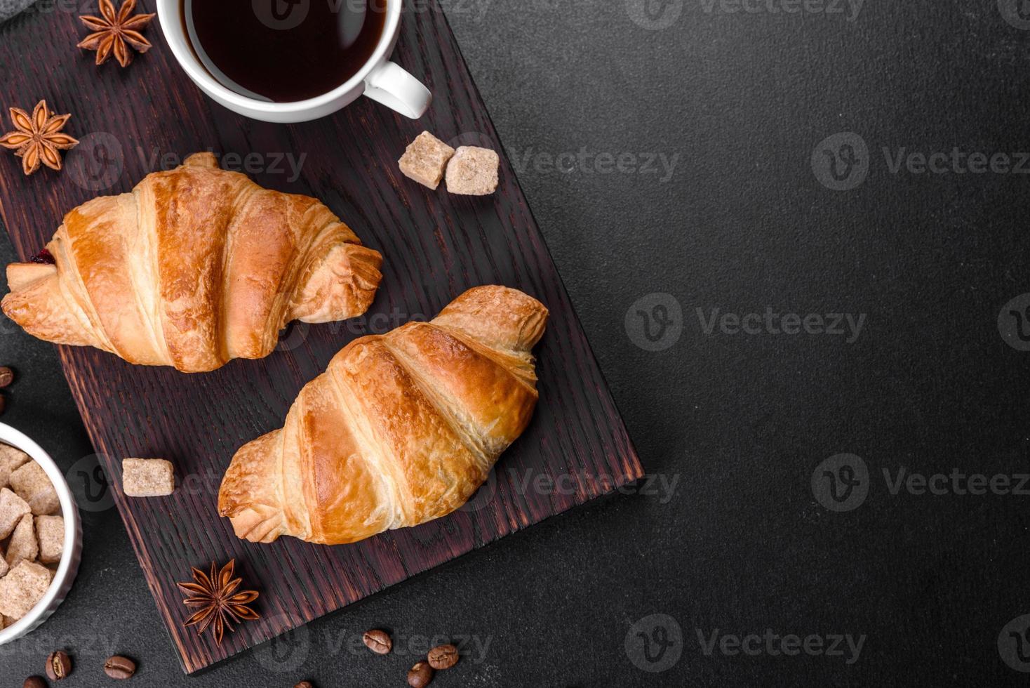 frisches knackiges leckeres französisches Croissant mit einer Tasse duftendem Kaffee foto