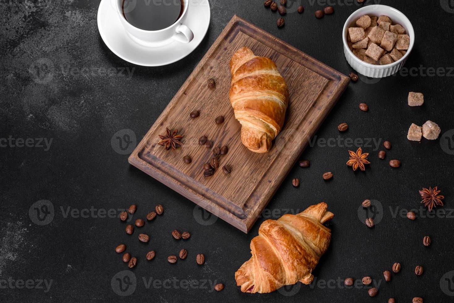 frisches knackiges leckeres französisches Croissant mit einer Tasse duftendem Kaffee foto