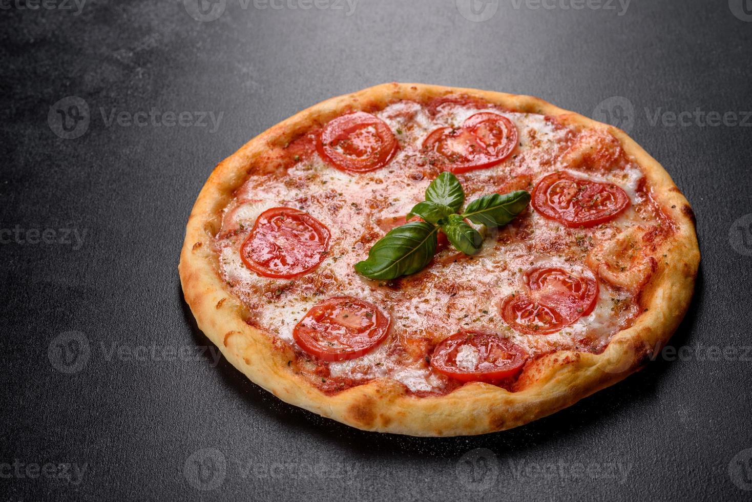 leckere frische Ofenpizza mit Tomaten, Käse und Basilikum auf Betongrund foto