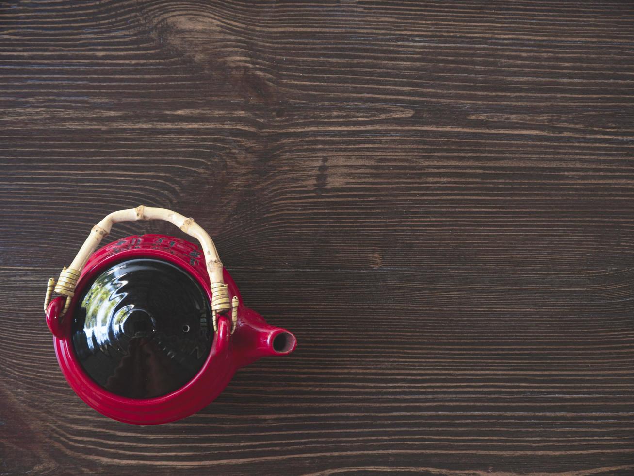 rote chinesische Teekanne auf einem Holztisch foto