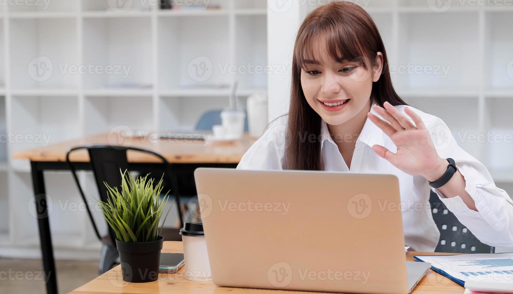 asiatische junge Geschäftsfrau, die sitzt und glücklich arbeitet foto