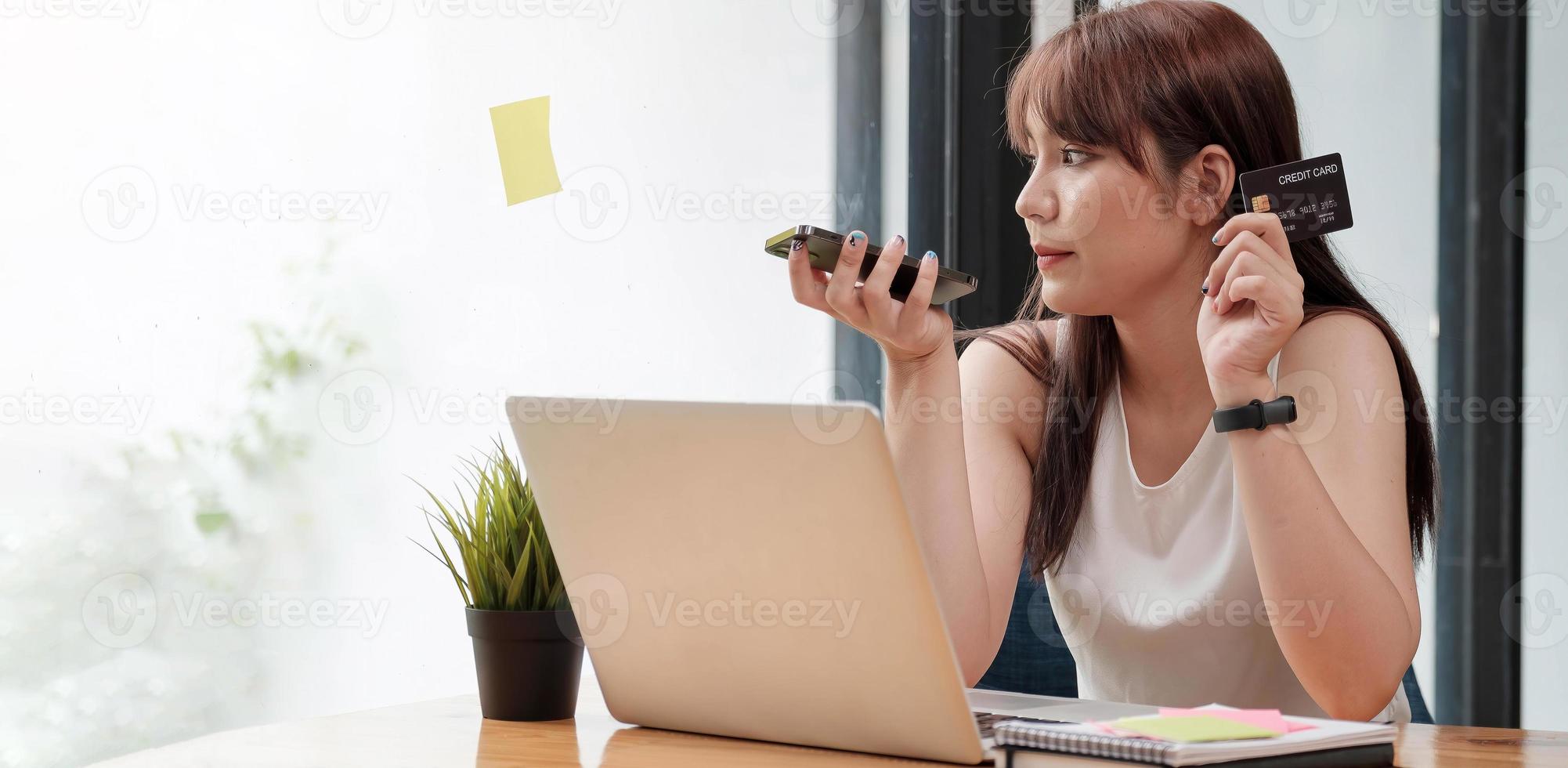 lächelnde Frau sitzt im Büro und telefoniert mit dem Handy foto