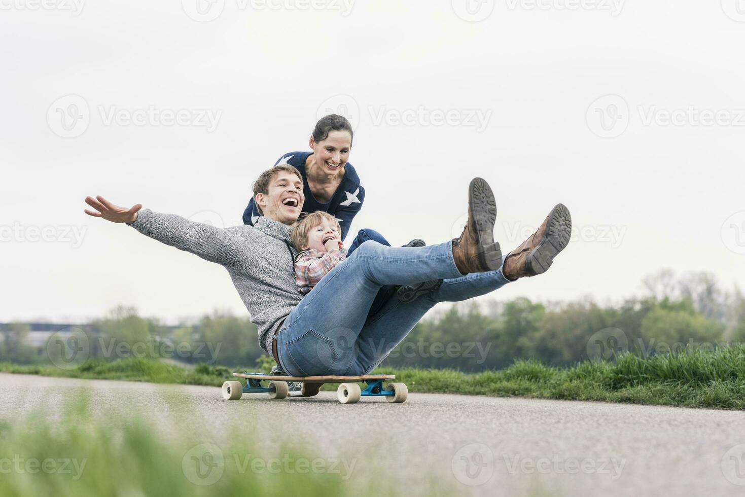 Vater und Sohn haben Spaß, spielen mit Skateboard draußen foto