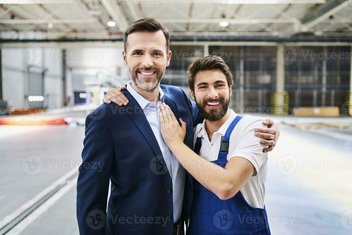 Porträt von glücklich Geschäftsmann und Arbeiter im ein Fabrik foto