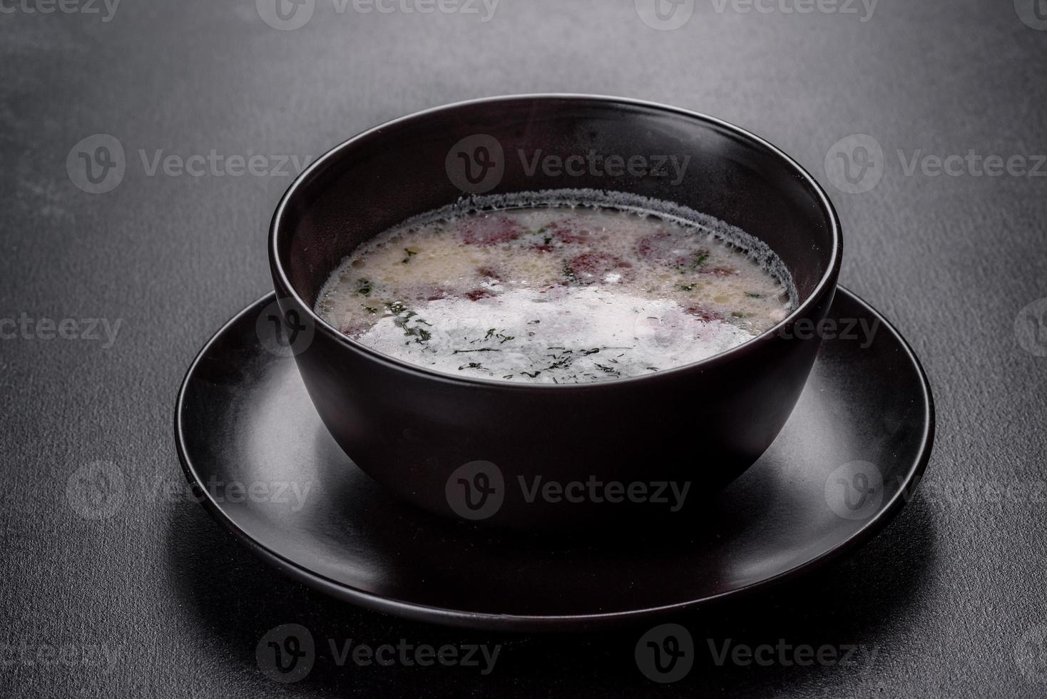 Käsesuppe mit Bratwürsten und Kräutern. leckere Frischkäsesuppe foto