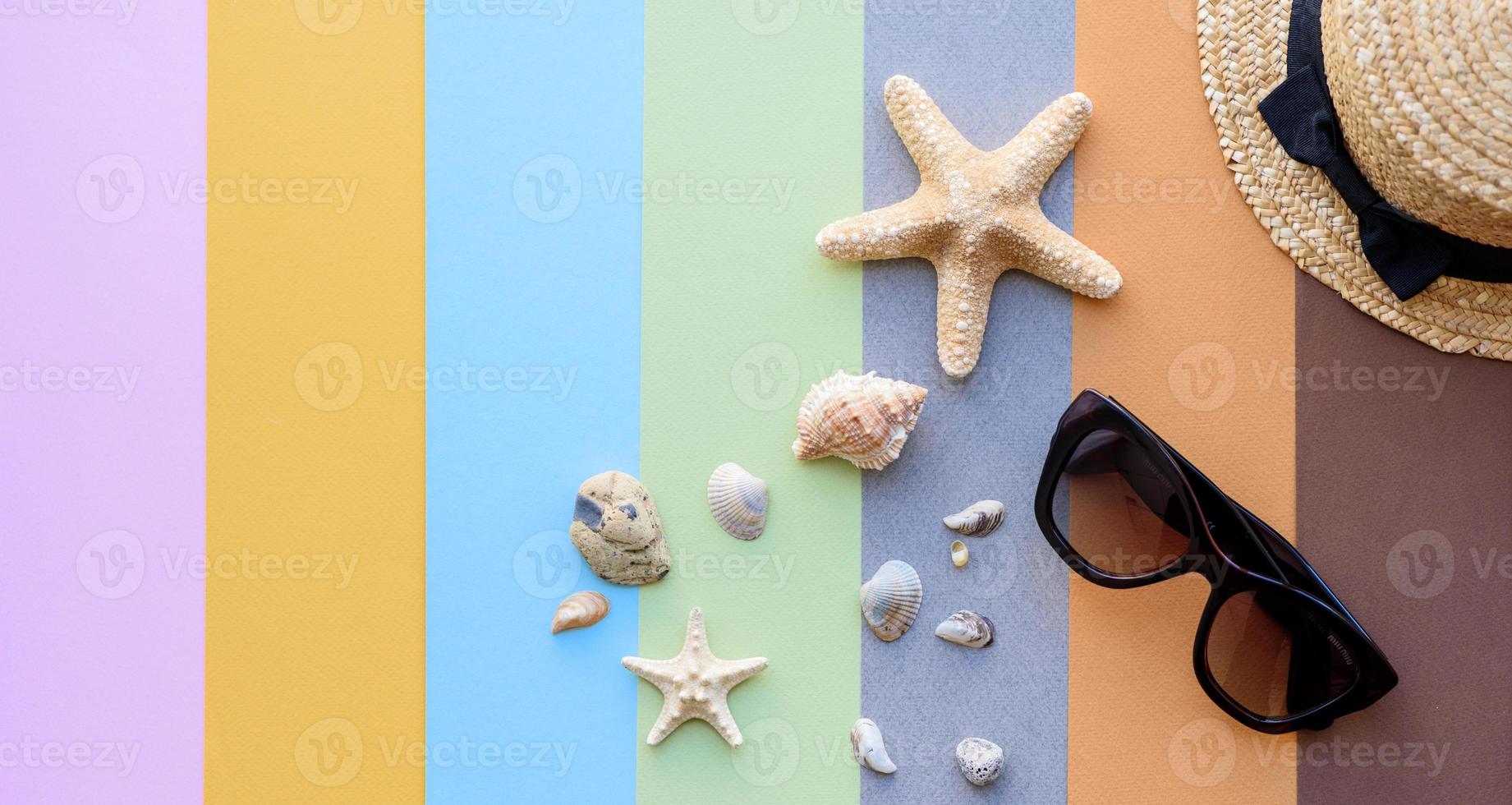 Brille und Hut mit Muscheln und Seesternen auf farbigem Hintergrund foto