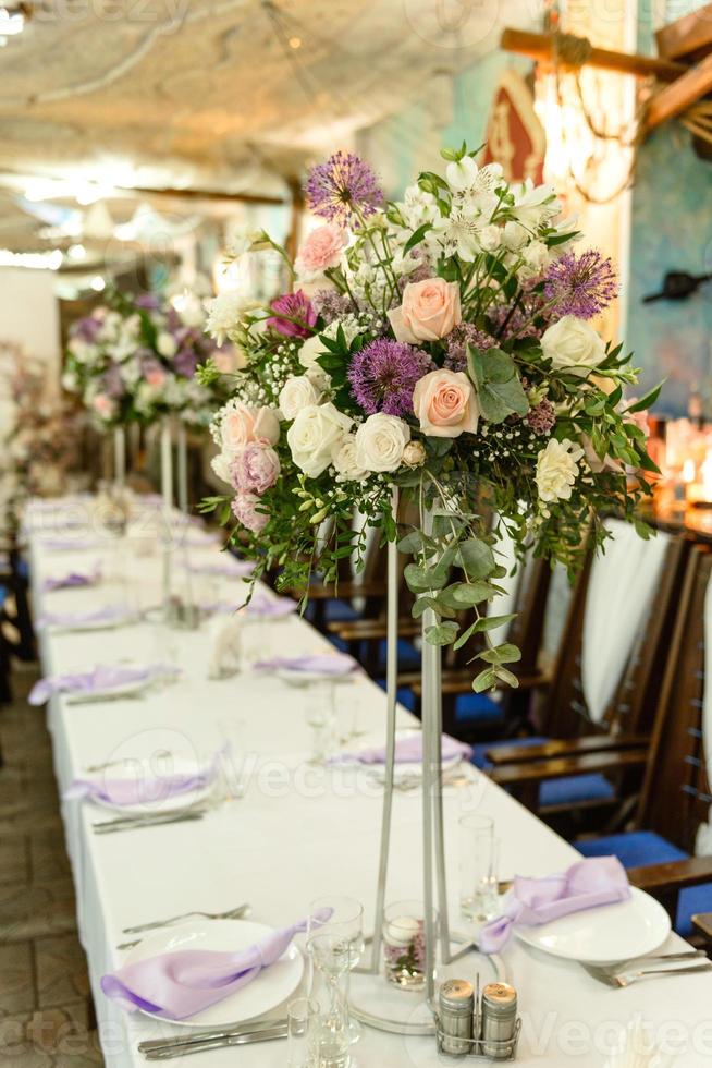 wunderschöne florale Kompositionen im Restaurant für die Hochzeitszeremonie foto