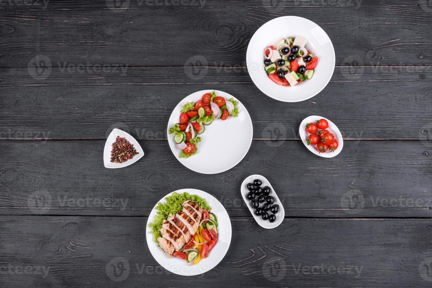 drei frische leckere Salate mit Hühnchen, Tomaten, Gurken, Zwiebeln und Gemüse mit Olivenöl foto