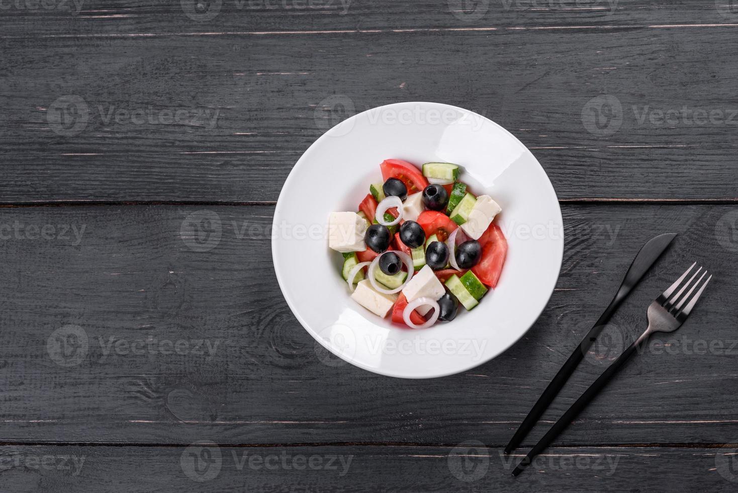 frischer leckerer griechischer Salat mit Tomaten, Gurken, Zwiebeln und Oliven mit Olivenöl foto