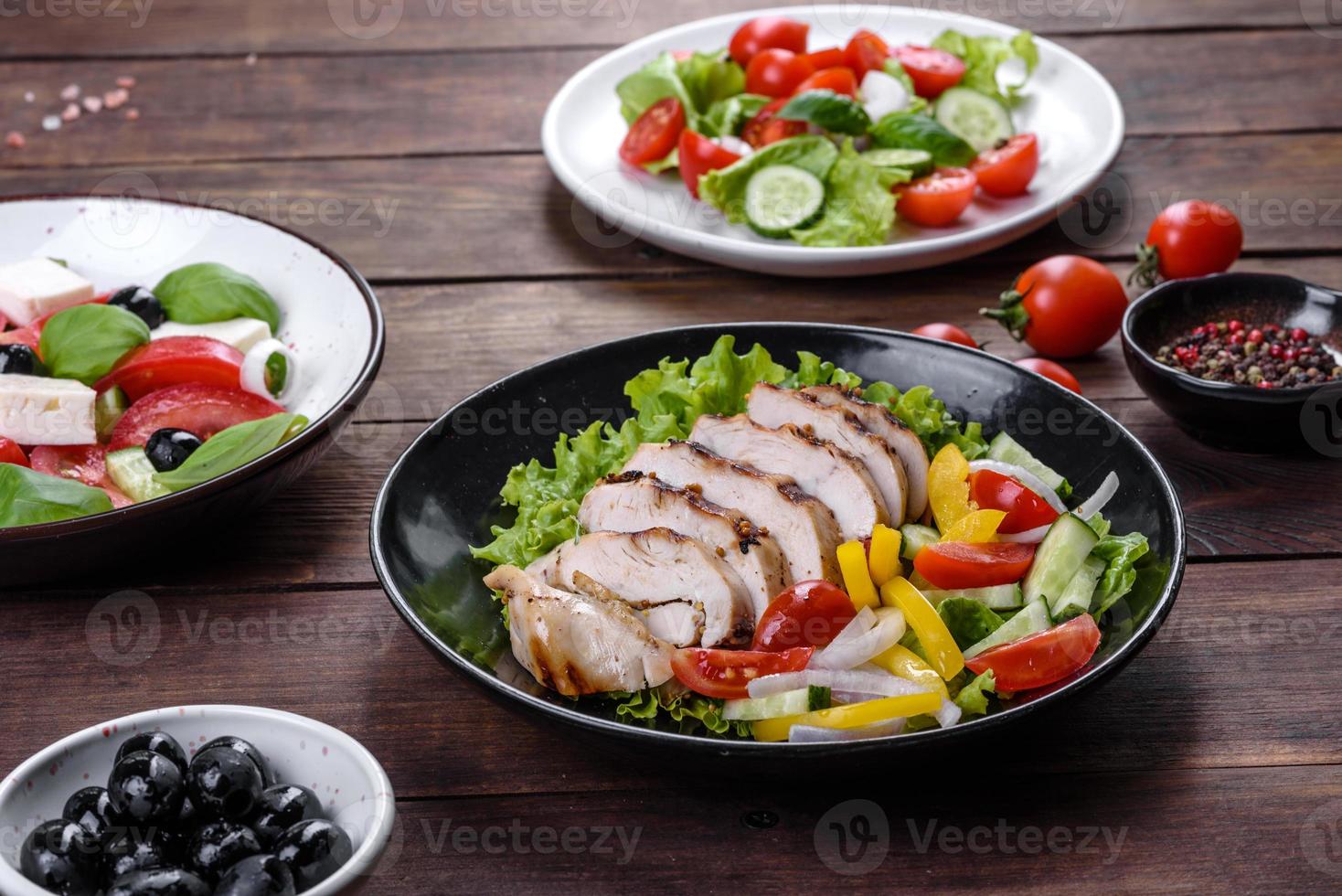 frischer leckerer Salat mit Hühnchen, Tomaten, Gurken, Zwiebeln und Gemüse mit Olivenöl foto