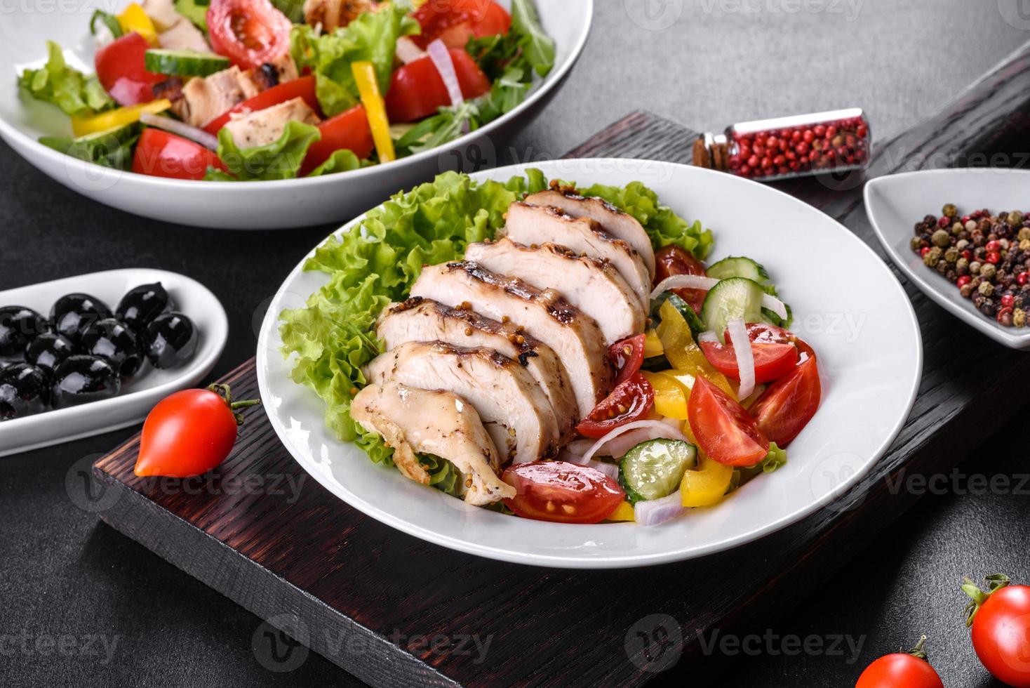 frischer leckerer Salat mit Hühnchen, Tomaten, Gurken, Zwiebeln und Gemüse mit Olivenöl foto