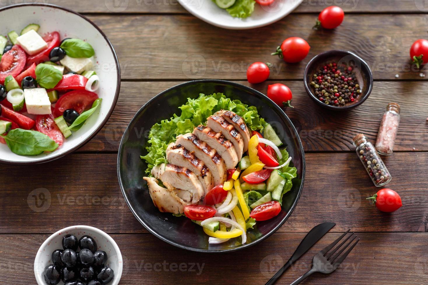 frischer leckerer Salat mit Hühnchen, Tomaten, Gurken, Zwiebeln und Gemüse mit Olivenöl foto