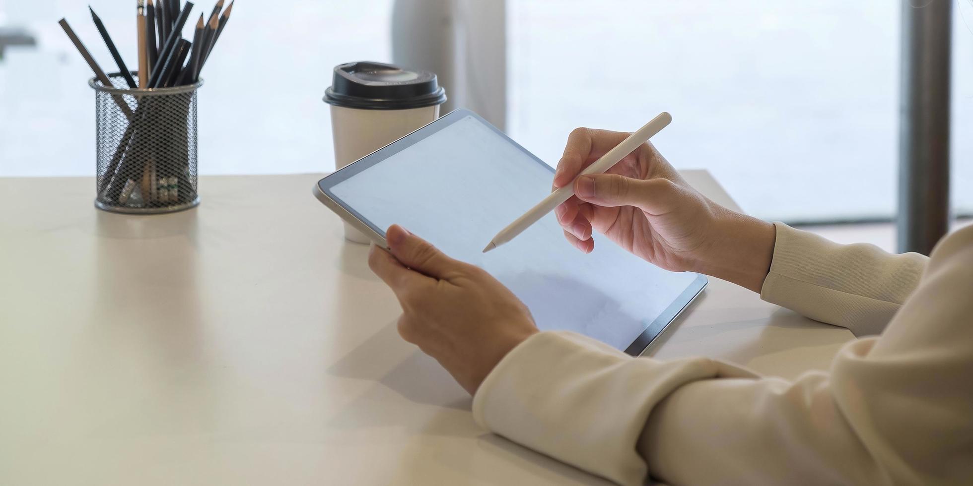 Frau mit digitalem Tablet mit leerem Bildschirm und Eingabestift foto