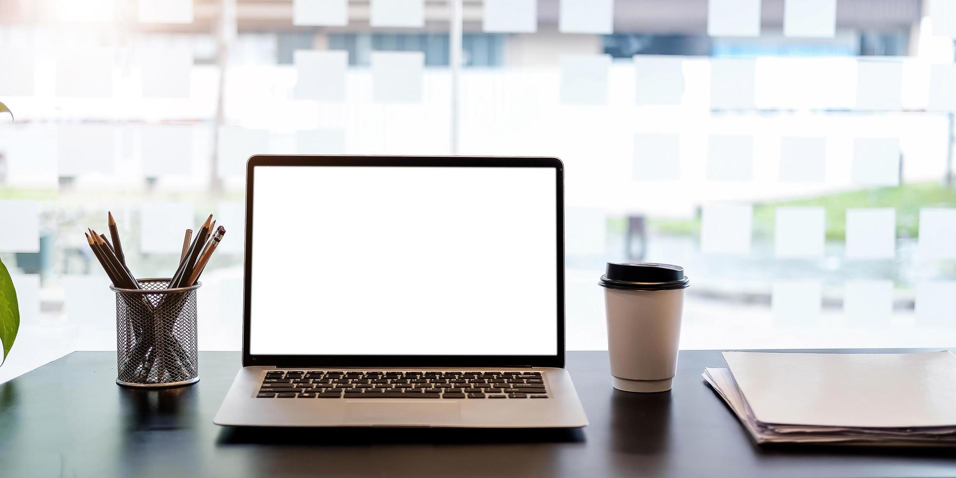 Laptop mit leerem Bildschirm auf schwarzem Tisch foto