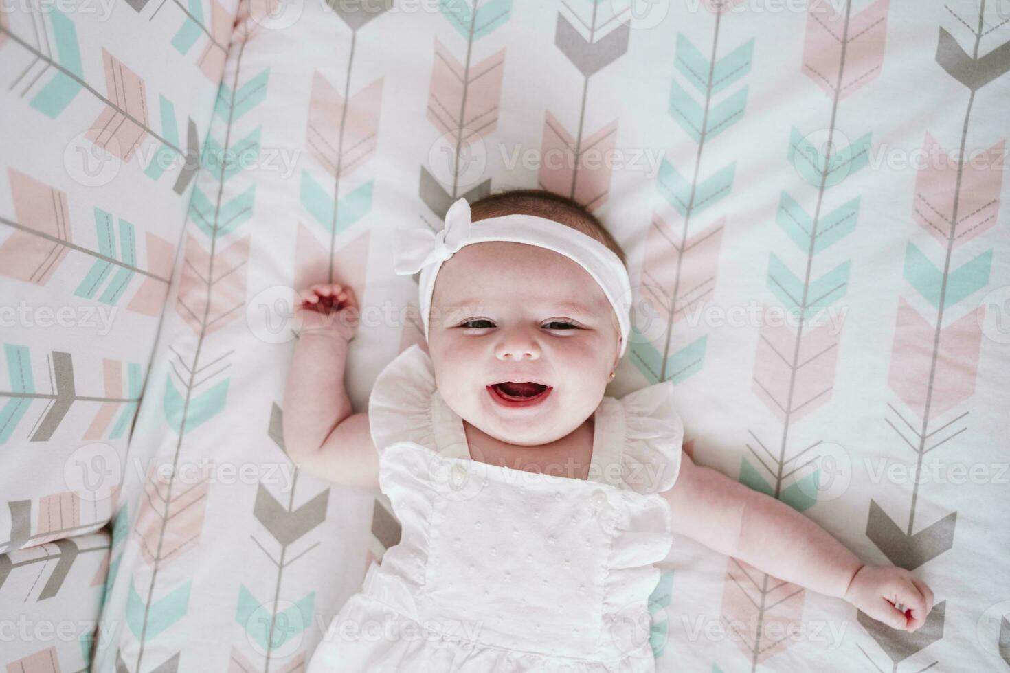 heiter Baby Mädchen Lügen im Krippe beim Zuhause foto