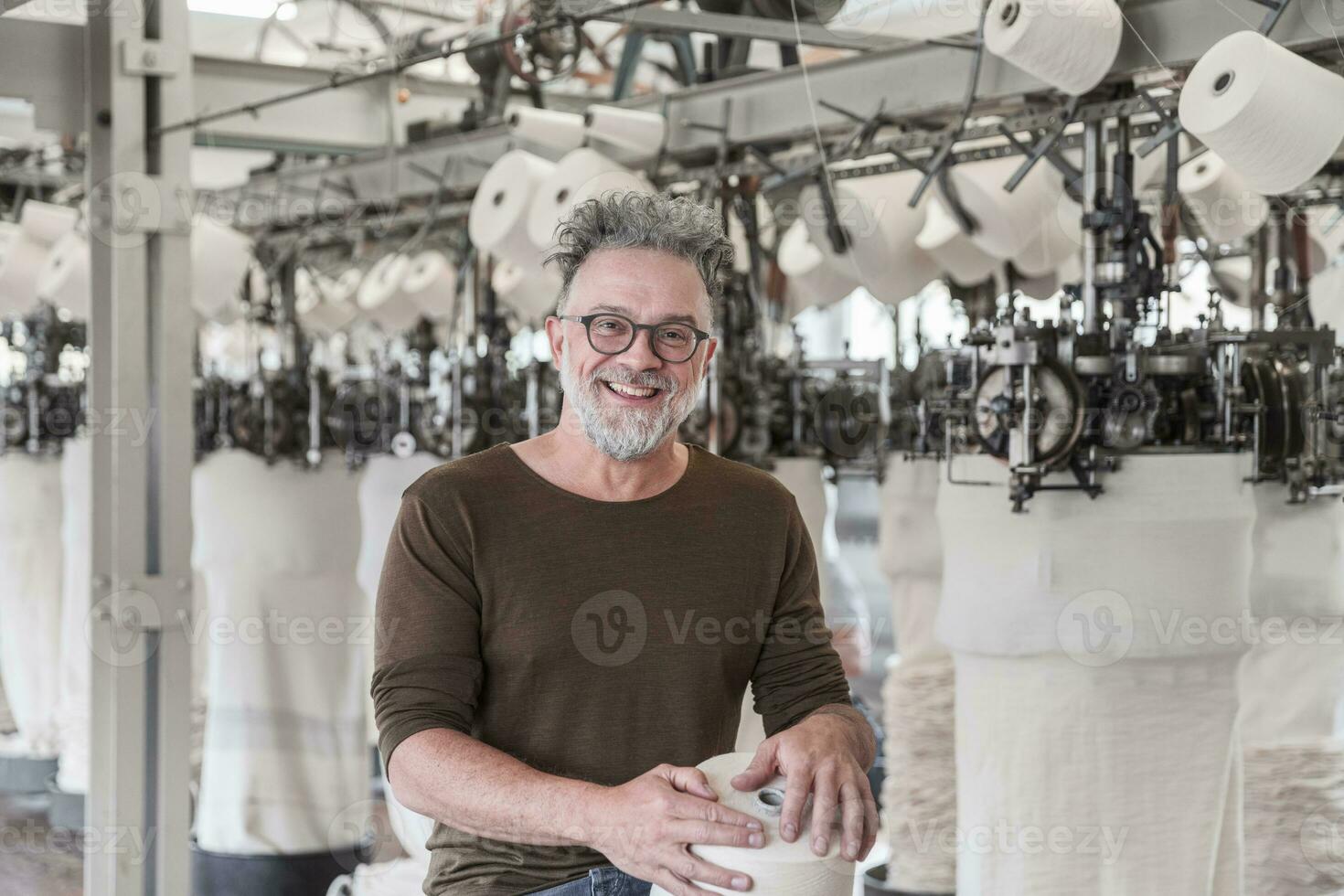 Porträt von ein glücklich reifen Mann im ein Textil- Fabrik foto