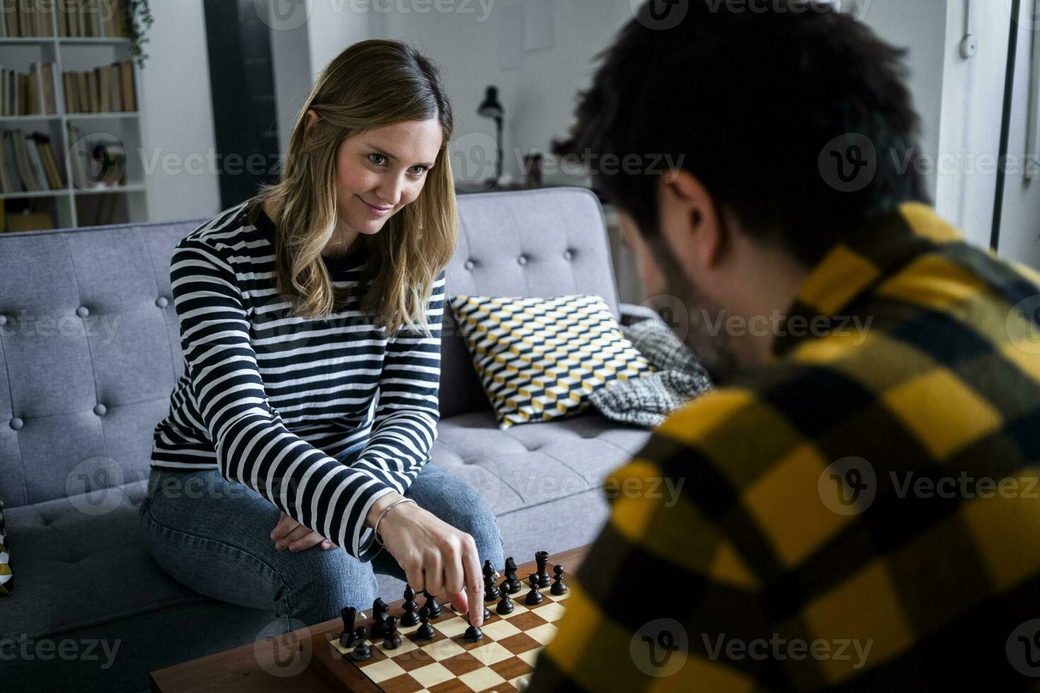 Frau und Mann spielen Schach beim Zuhause foto