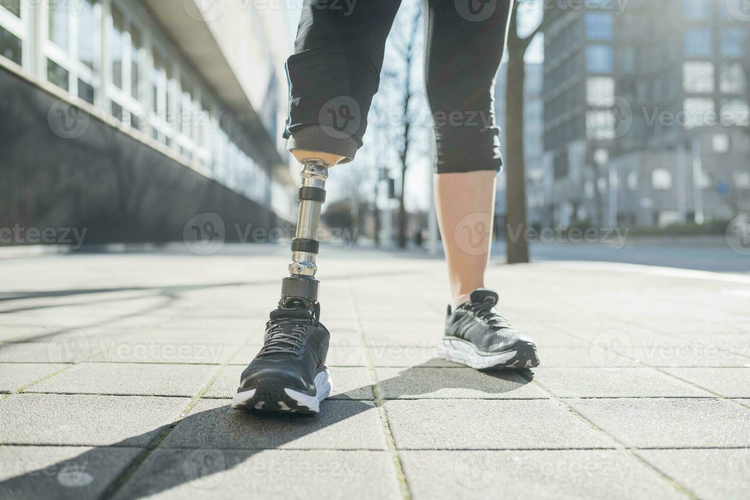 Nahansicht von Beine von sportlich Frau mit Bein Prothese im das Stadt foto