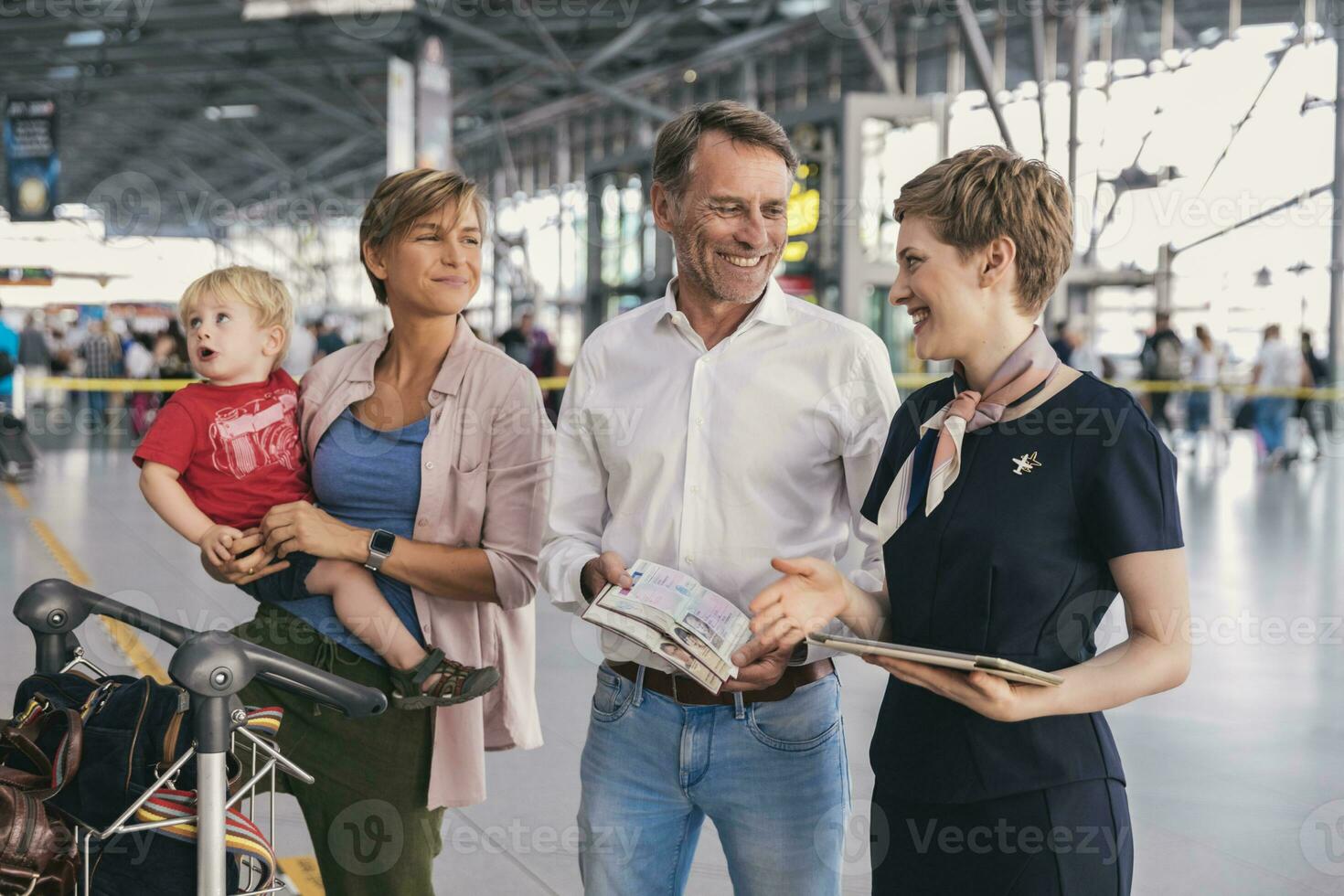 glücklich Familie zeigen Pässe zu Fluggesellschaft Mitarbeiter beim das Flughafen foto