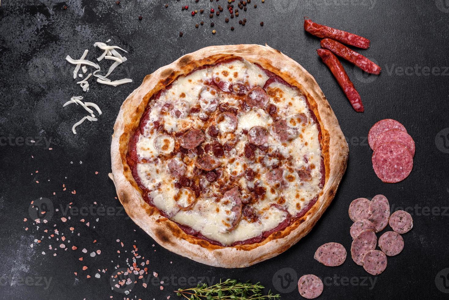 frische leckere italienische pizza mit vier fleischsorten auf dunklem betonhintergrund foto