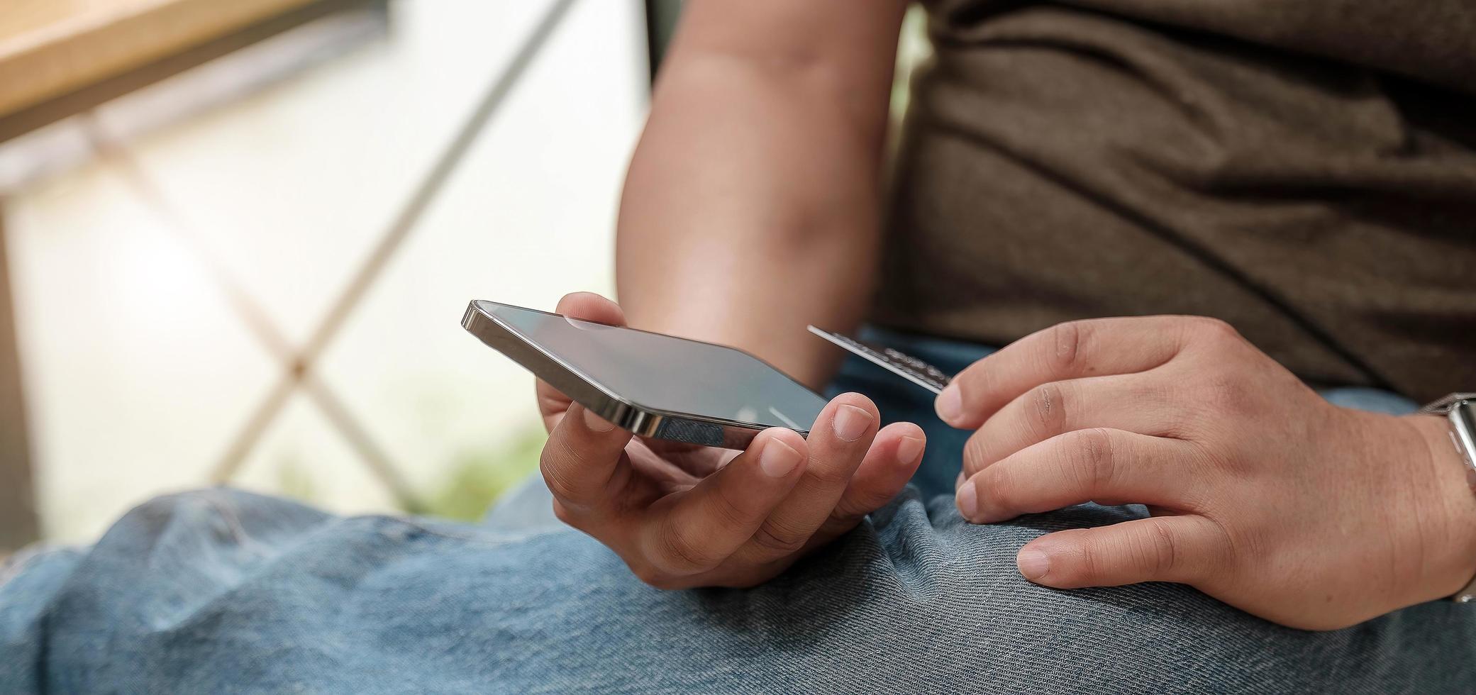 Mann mit Smartphone und Kreditkarte foto