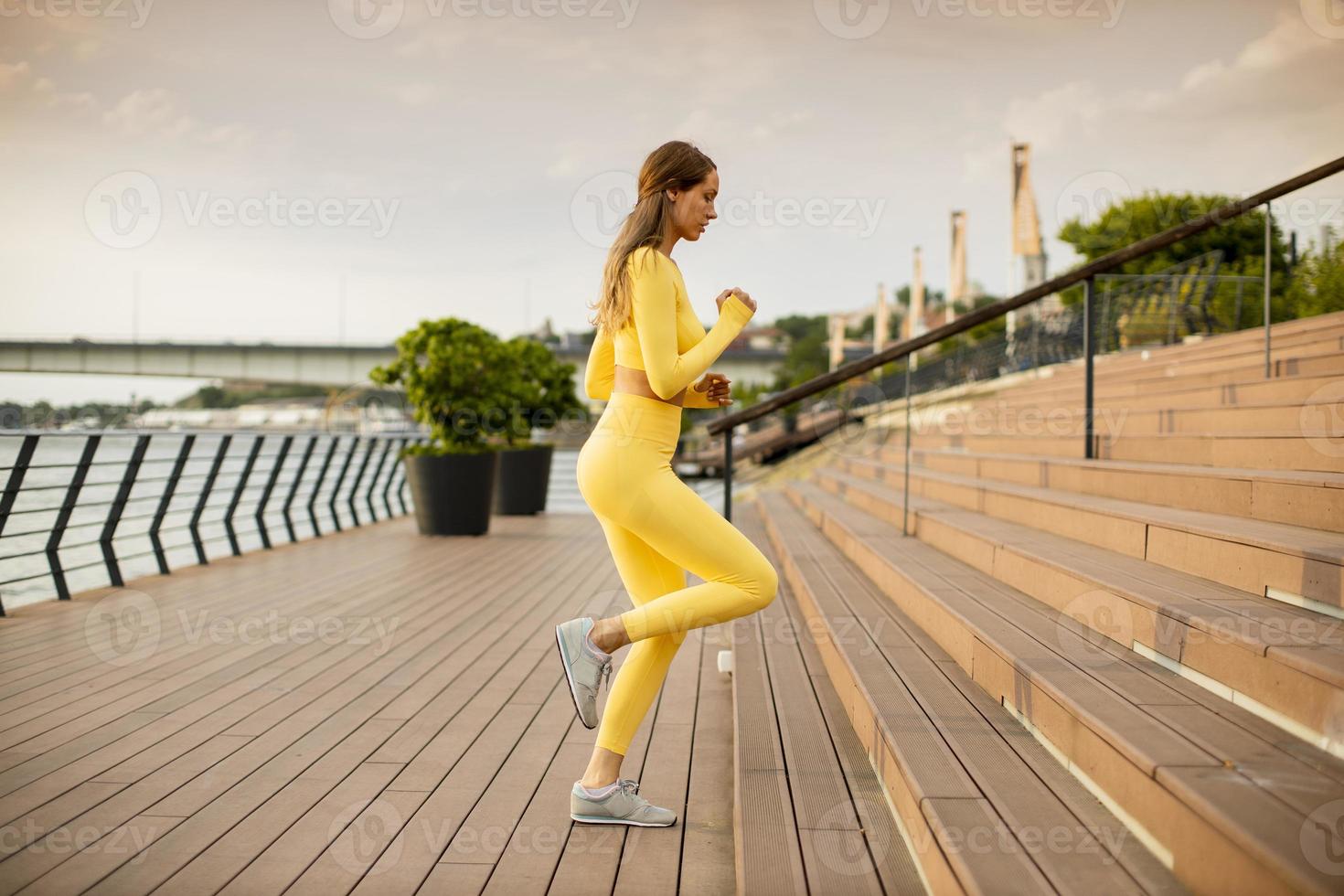 junge Frau läuft auf der Treppe am Flussufer foto