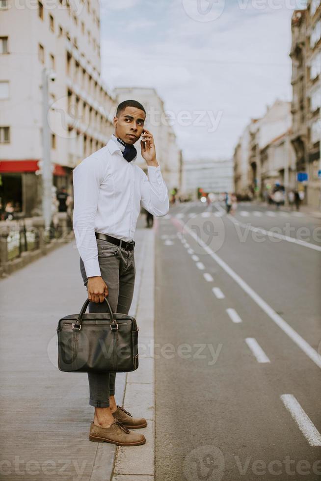 junger afroamerikanischer Geschäftsmann mit einem Mobiltelefon mobile foto