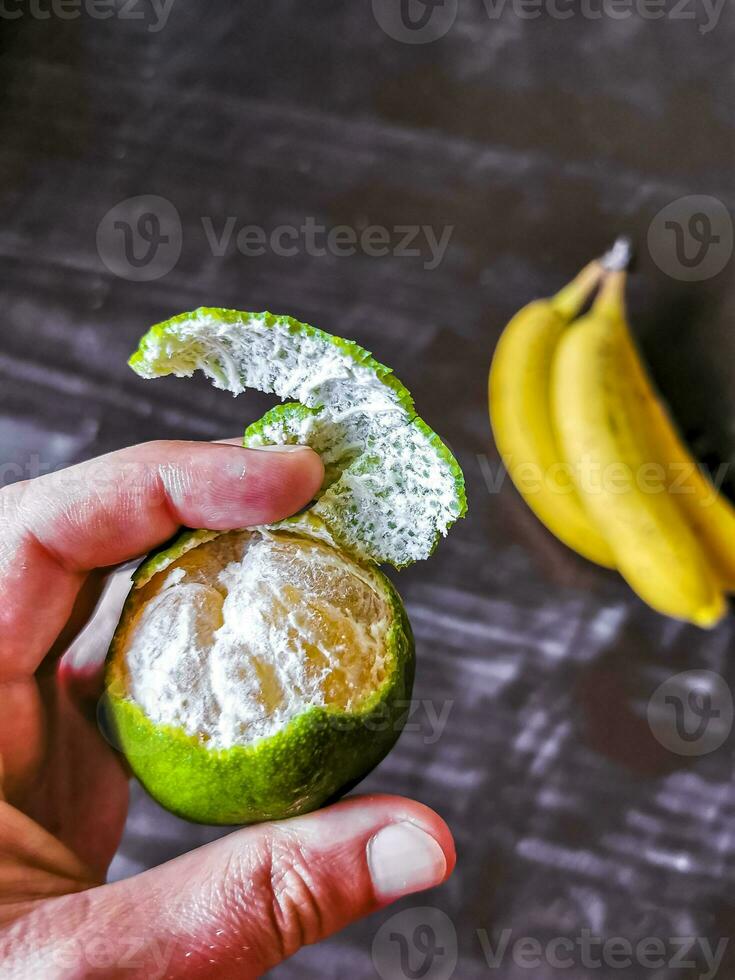 Hände schälen ein Grün Orange Zitrusfrüchte Obst im Mexiko. foto