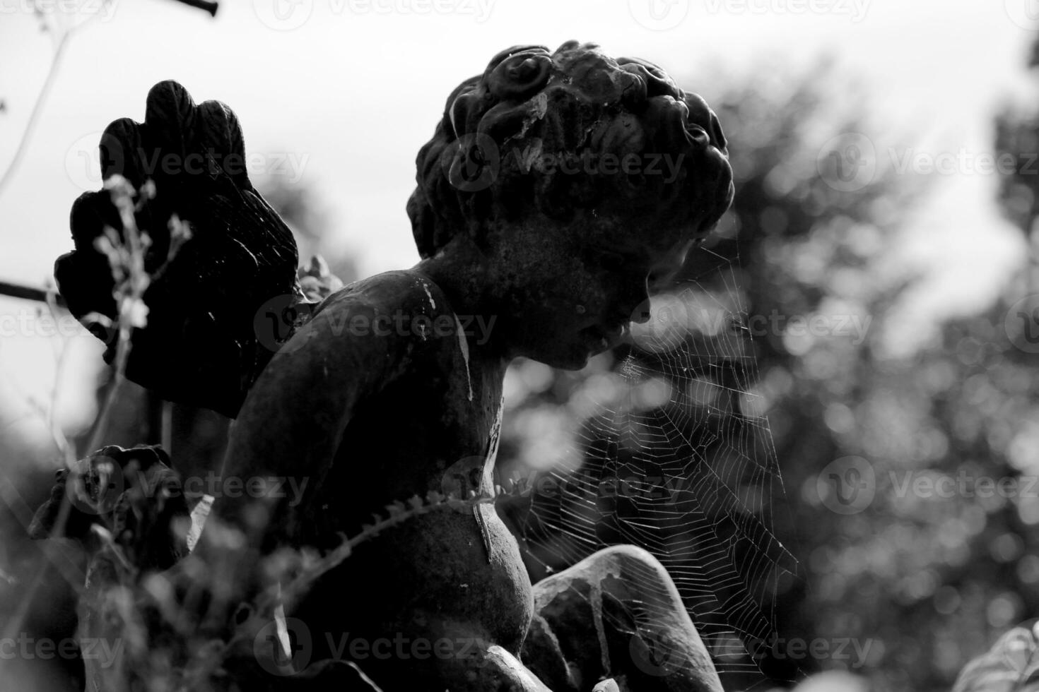 schön Amor Engel Statue mit Flügel auf zurück im Jahrgang Garten foto