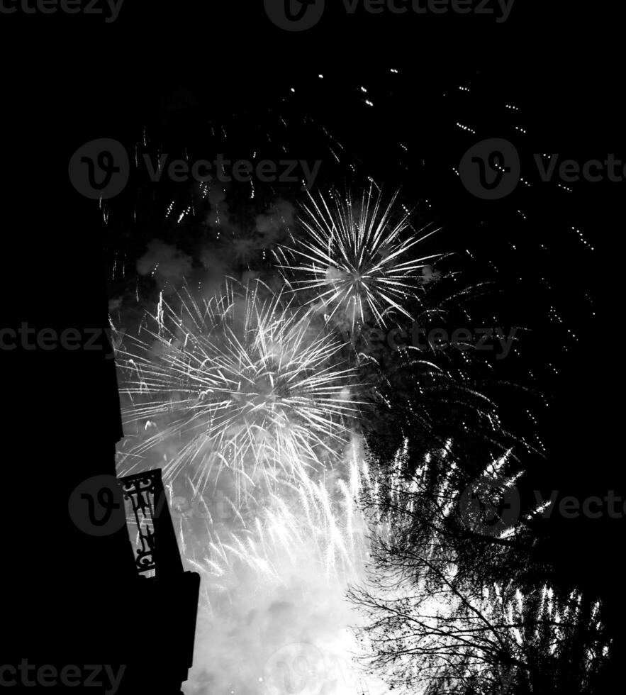 ein buntes Feuerwerk in den dunklen Nachthimmel platzen lassen foto