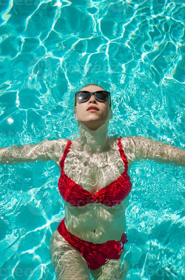 junges schönes sexy Mädchen, das es genießt, im privaten Pool zu schwimmen und sich in der Sonne zu entspannen? foto