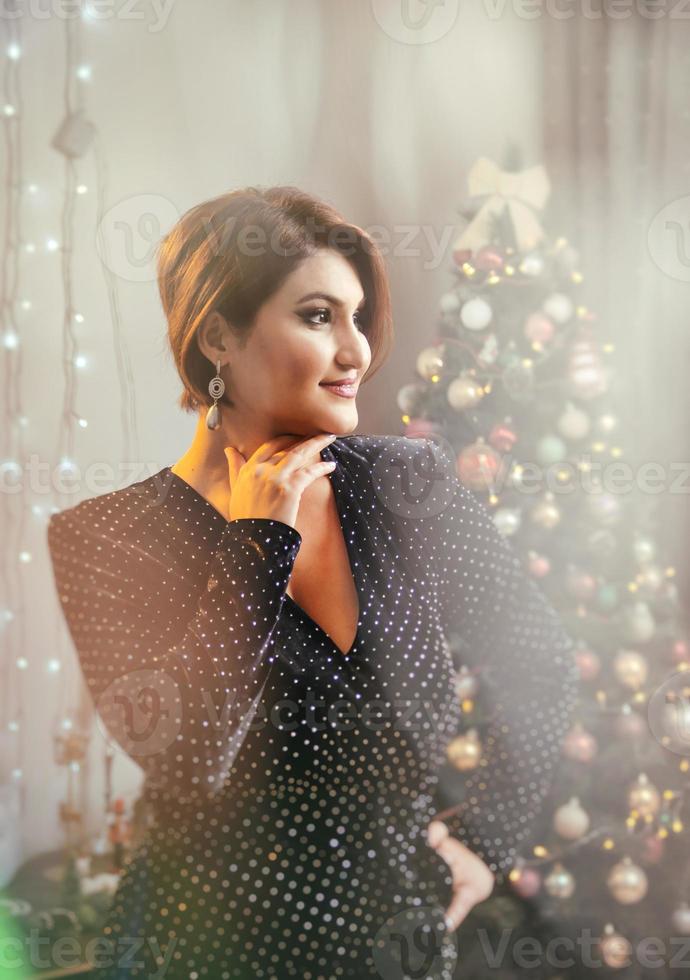 Weihnachtsschießen. schönes Modell mit Neujahrsgeschenken auf dem Hintergrund eines Weihnachtsbaums. foto