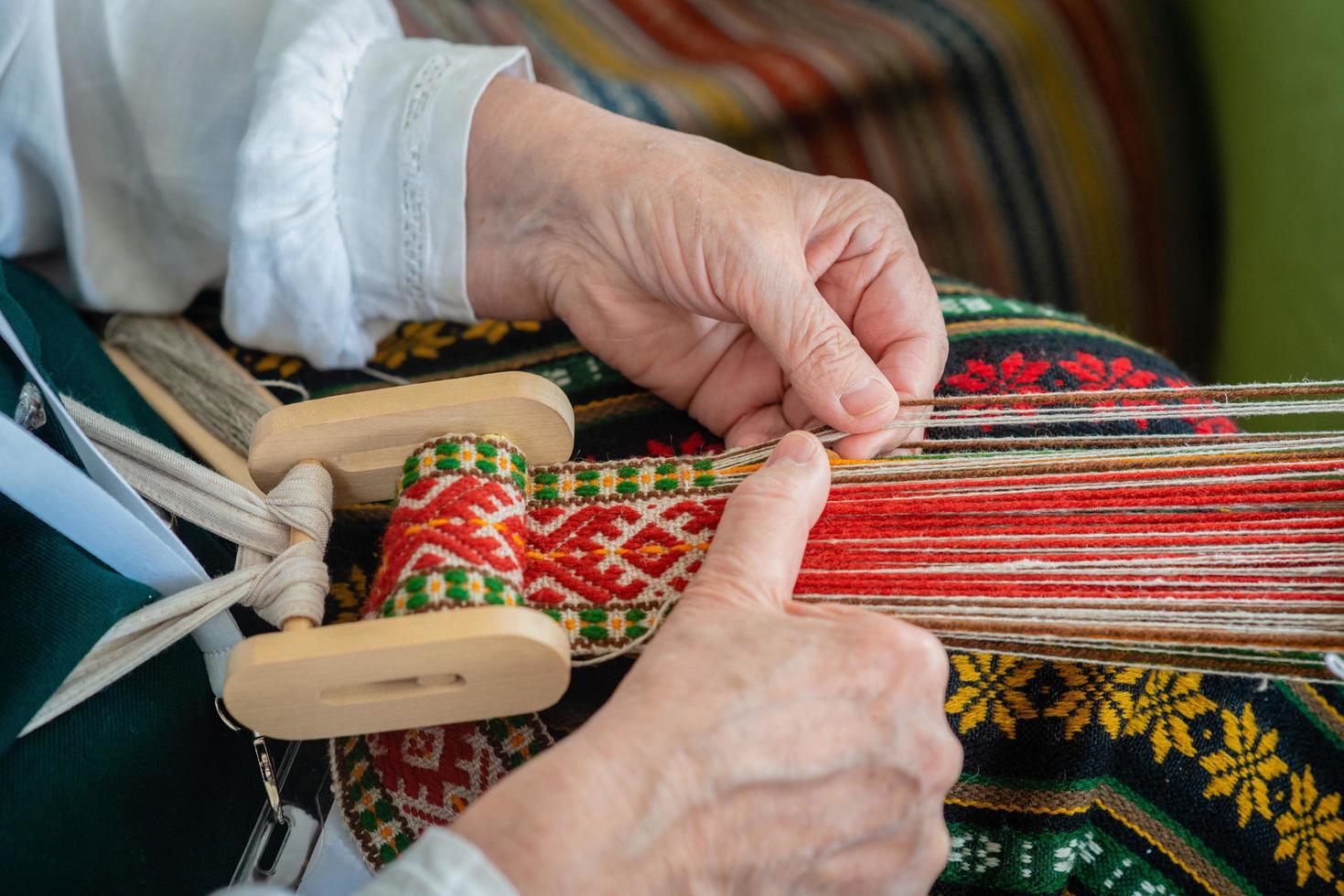 Frau, die am Webstuhl arbeitet. traditionelles ethnisches Handwerk der Ostsee. - Bild foto
