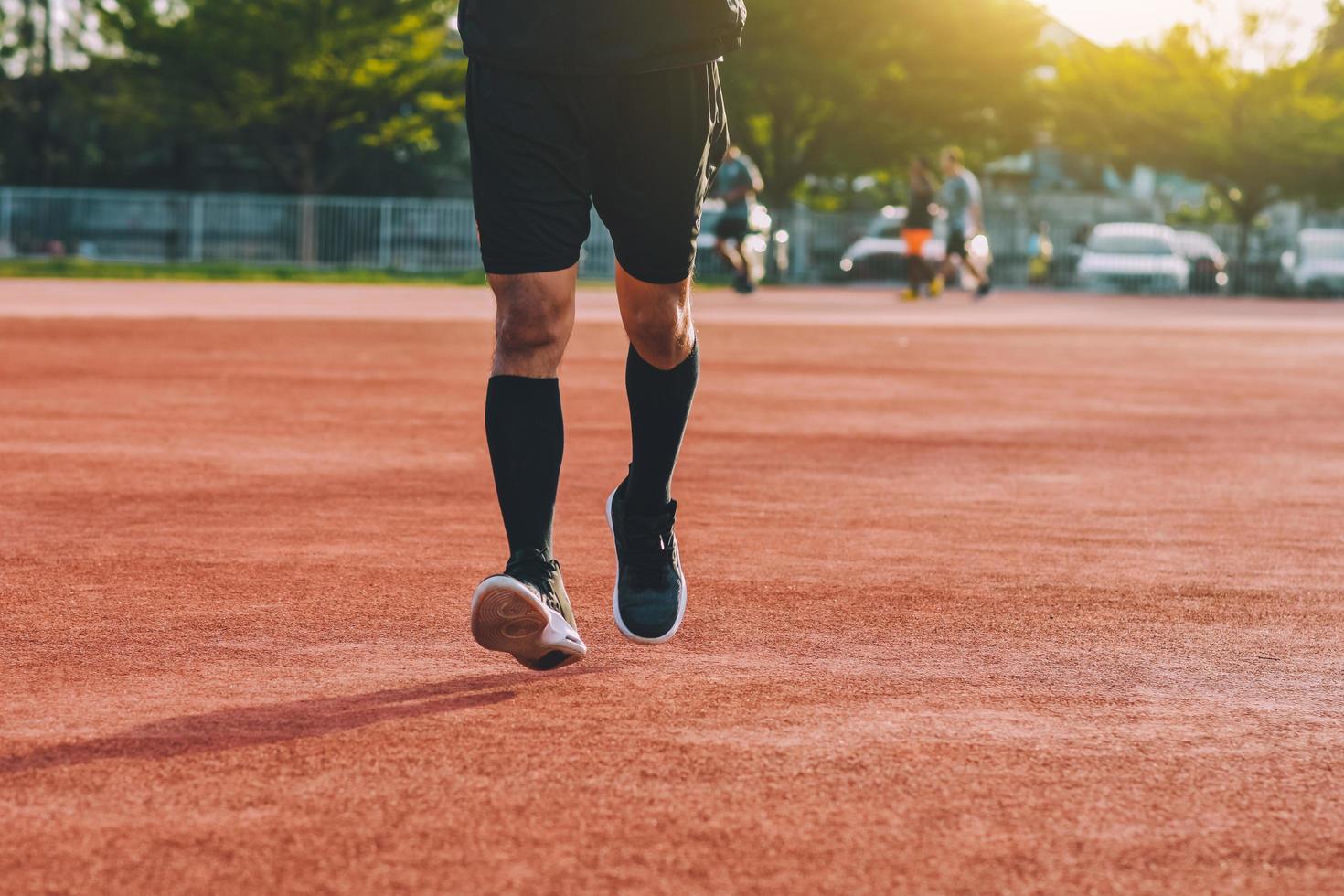 Läufer, der abends bei Sonnenlicht joggt oder läuft foto