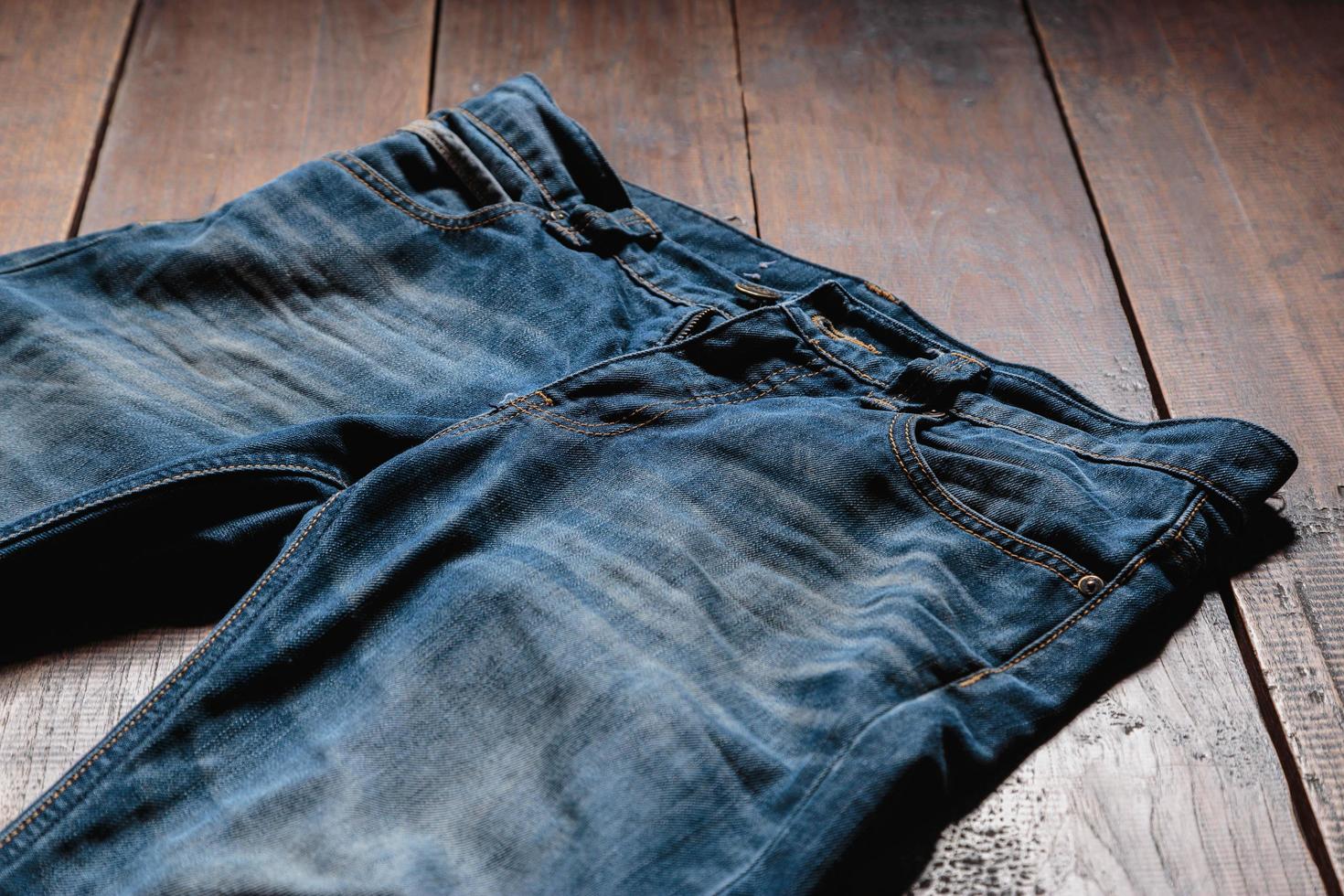blaue Herren Jeans Jeanshose auf Holzuntergrund. Mode-Kleidung-Konzept. foto