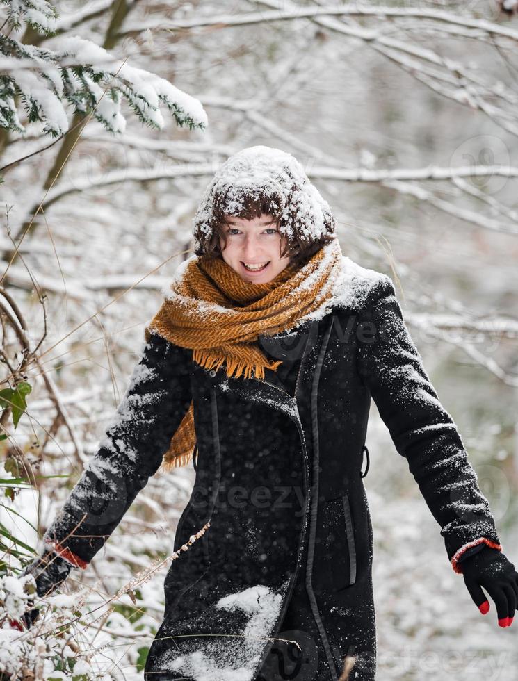 junges Mädchen in einem verschneiten Wald foto