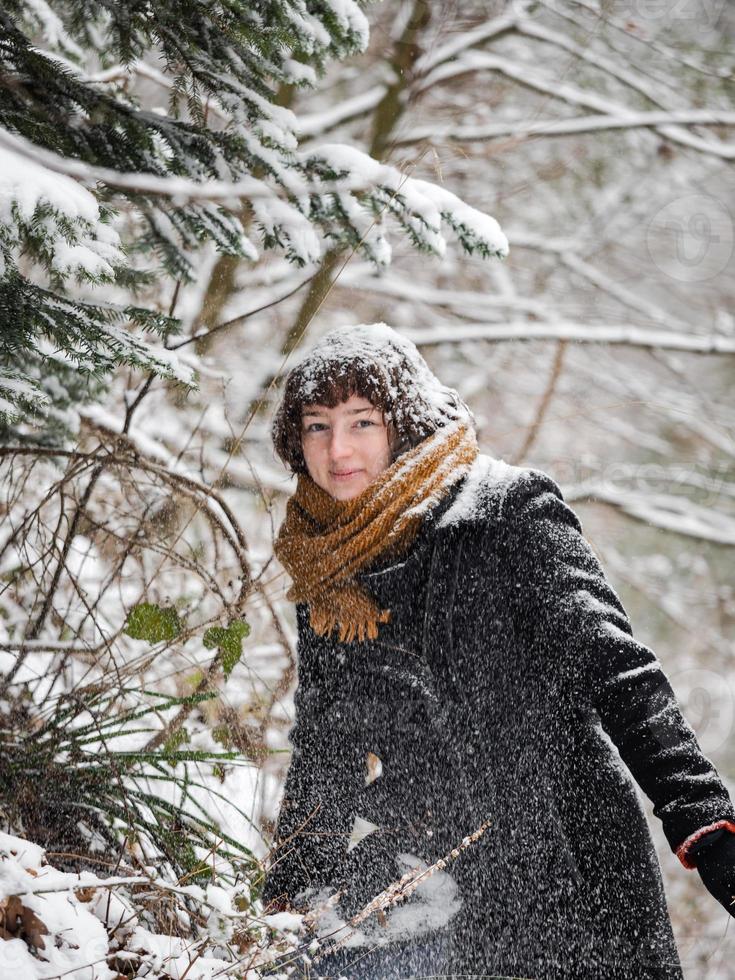 junges Mädchen in einem verschneiten Wald foto