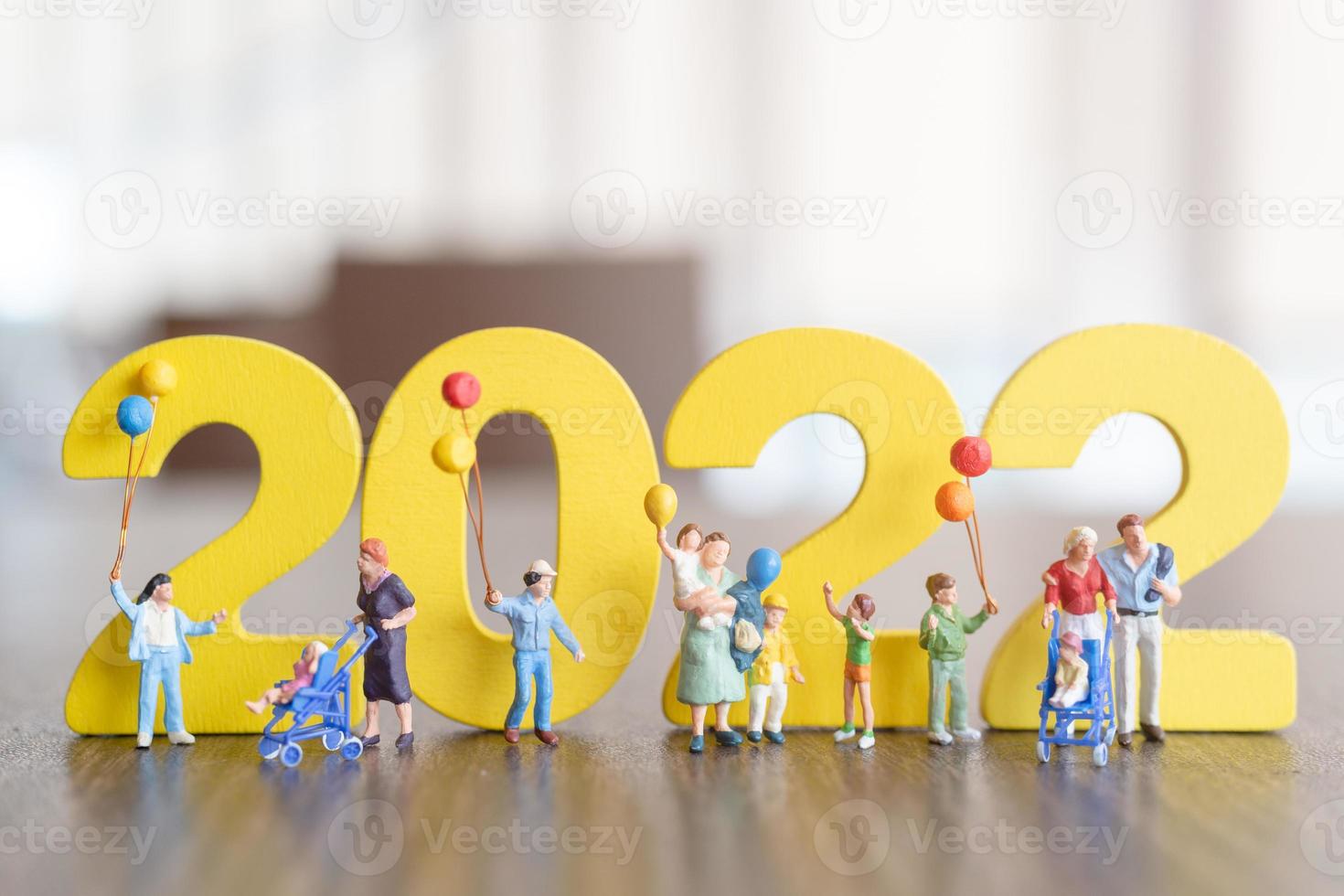 Miniaturmenschen glückliche Familie mit Ballon auf weißer Zahl 2022 foto