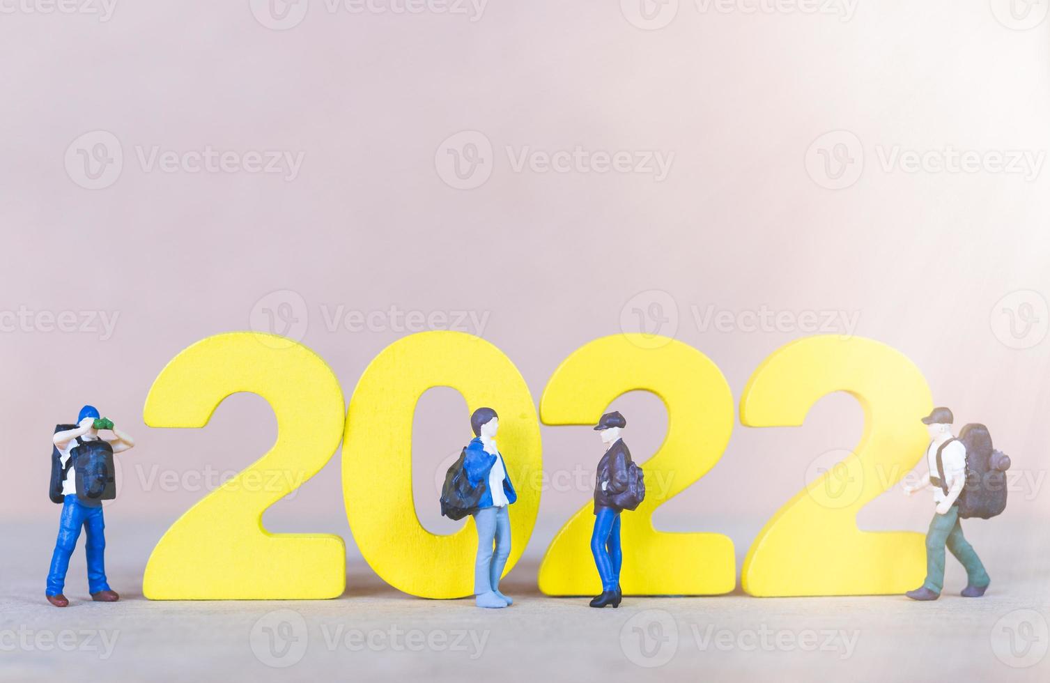 Miniatur-Menschen-Backpacker, der auf Holznummer 2022 steht foto