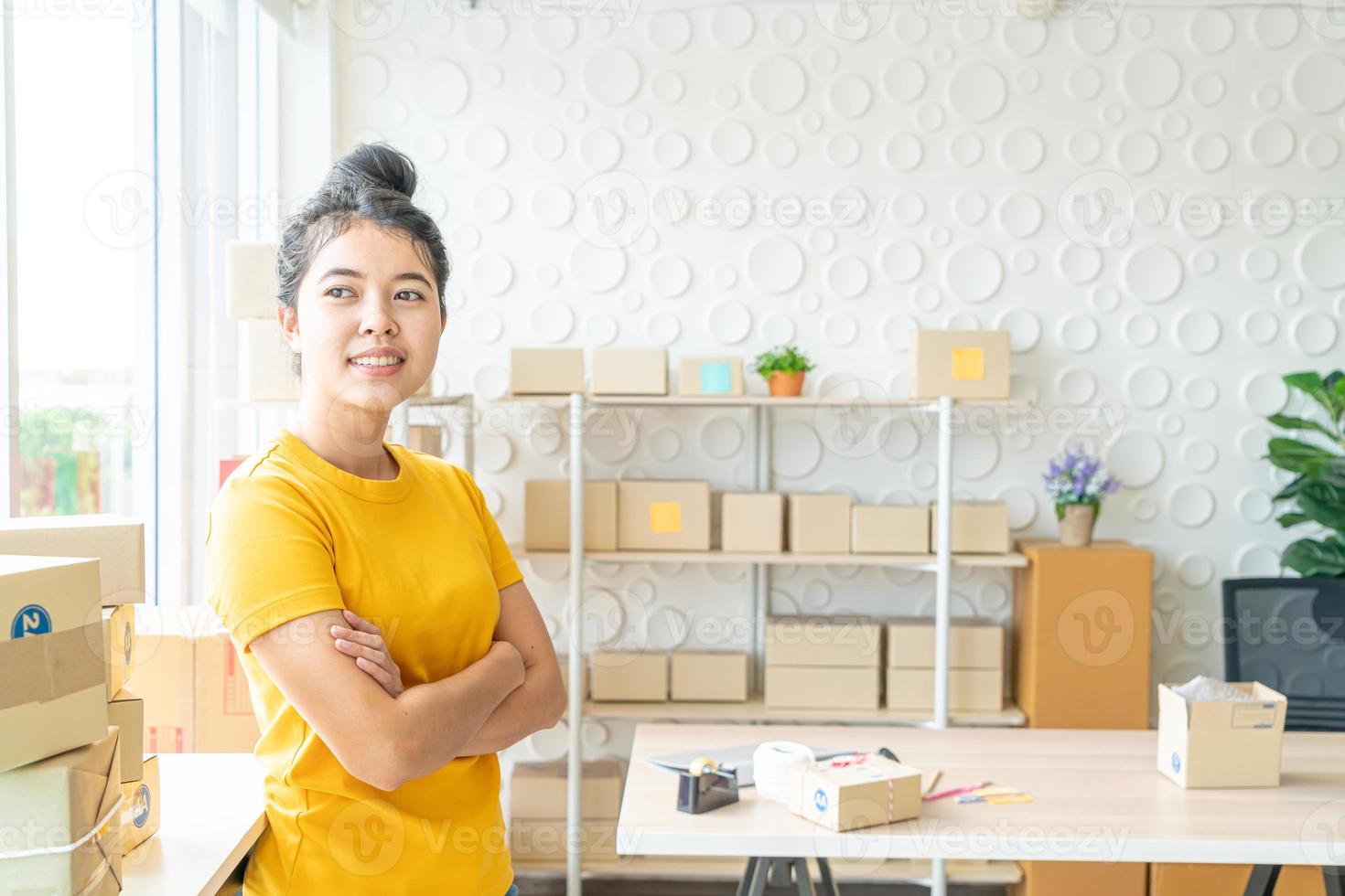 asiatische Geschäftsinhaberin, die zu Hause mit Verpackungsbox am Arbeitsplatz arbeitet - Online-Shopping-KMU-Unternehmer oder freiberufliches Arbeitskonzept foto