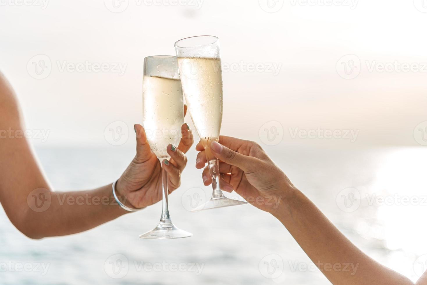 Hand hält ein Glas Wein trinken auf Sonnenuntergang Meer Hintergrund. foto