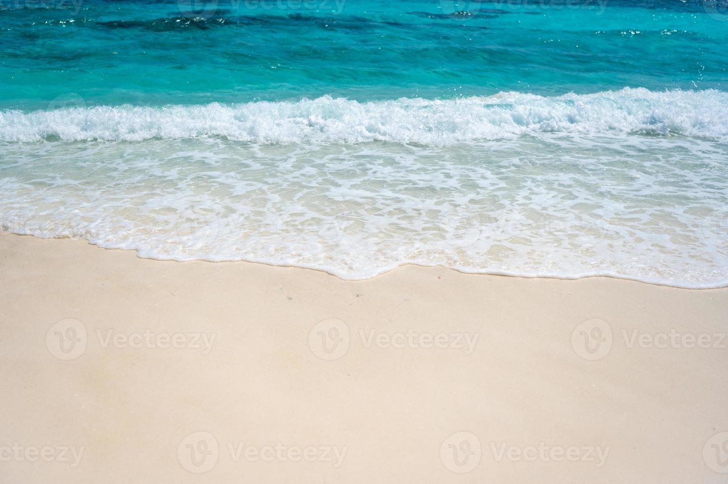 klare Meereswellen und weißer Sandstrand im Sommer. foto