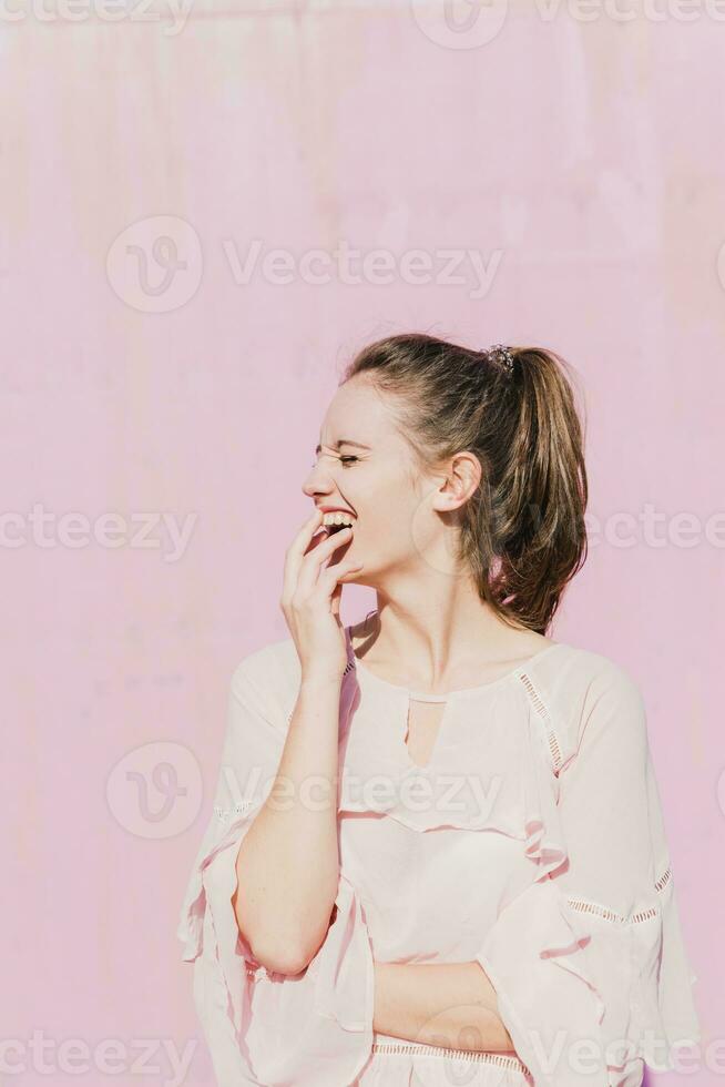 Lachen jung Frau im Vorderseite von Rosa Mauer foto