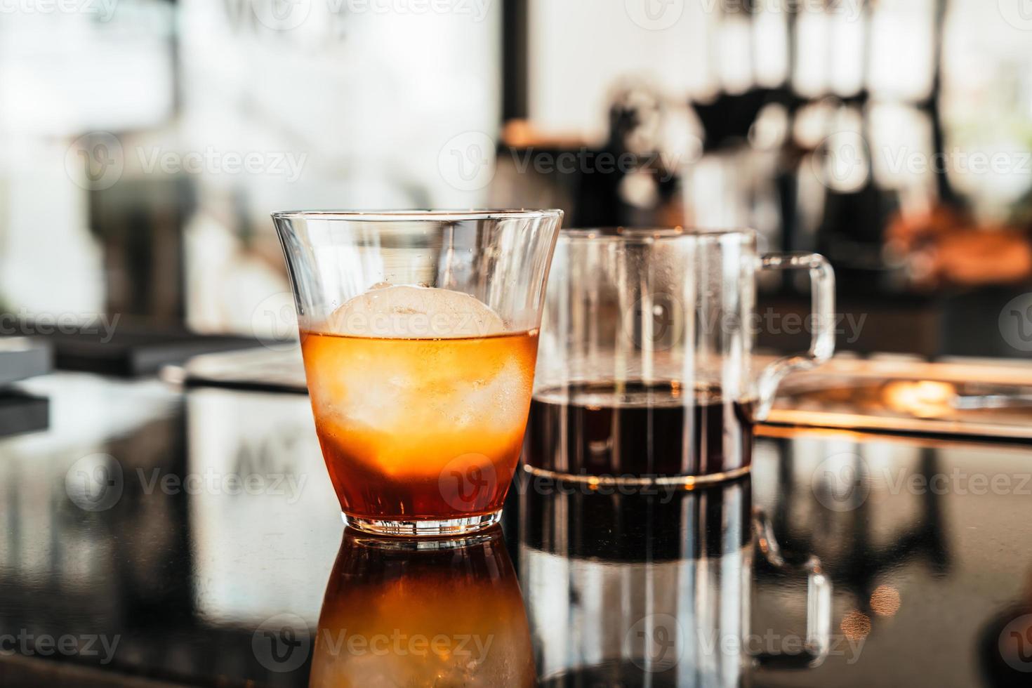 Cold Drip Arabica schwarzer Kaffee im Glas mit Eiskugel foto