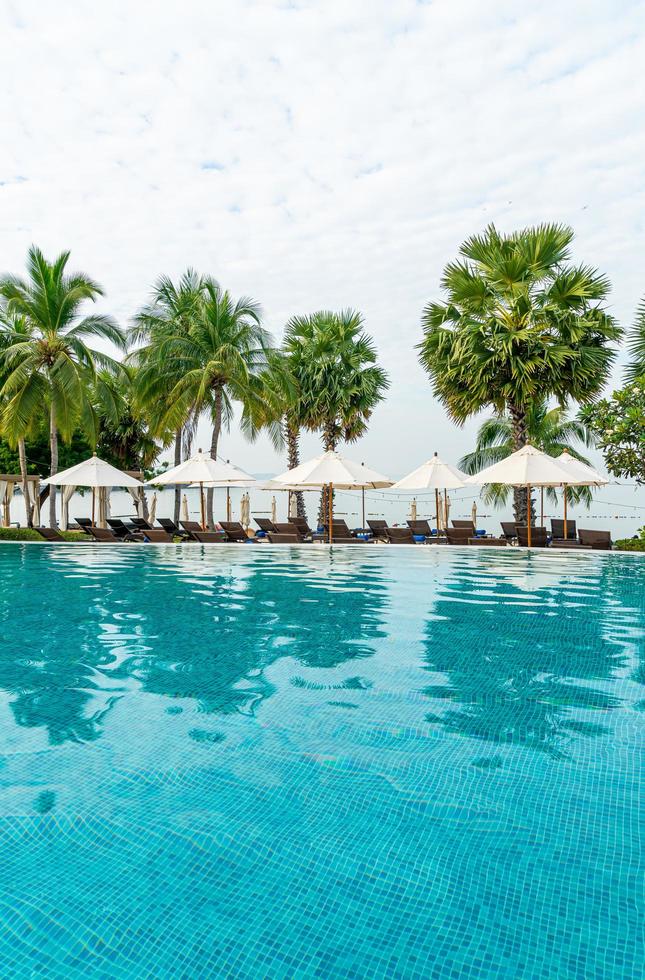 leerer Strandkorb mit Sonnenschirm um den Pool herum foto