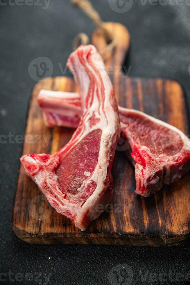 Schnitzel Lamm Fleisch roh auf das Knochen Scheibe Mahlzeit Essen Snack auf das Tabelle Kopieren Raum Essen Hintergrund rustikal oben Aussicht foto