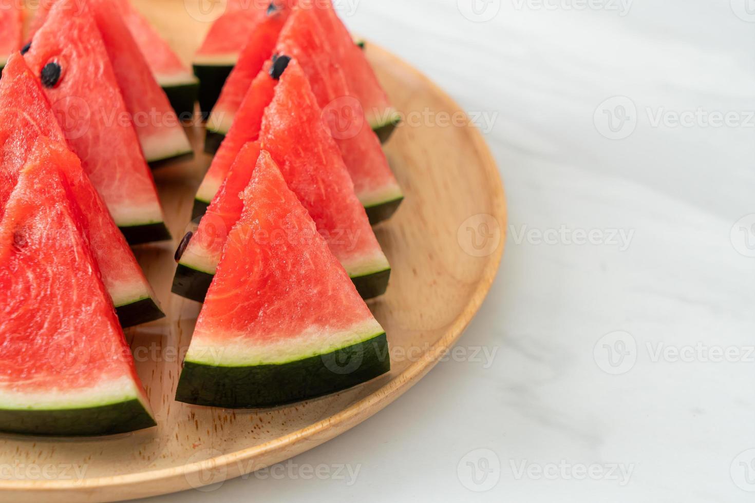 frische Wassermelone auf Holzteller geschnitten foto