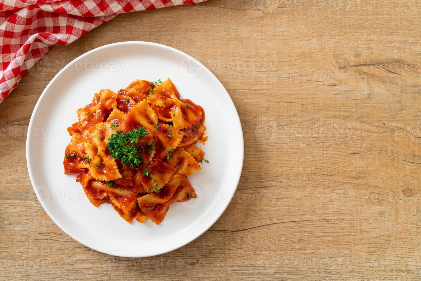 Farfalle-Nudeln in Tomatensauce mit Petersilie - italienische Küche foto